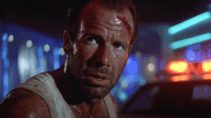 Escena de John McClane descalzo entre cristales rotos.