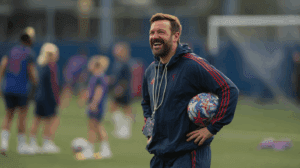 Ted Lasso entrenador sonriente durante un partido de fútbol